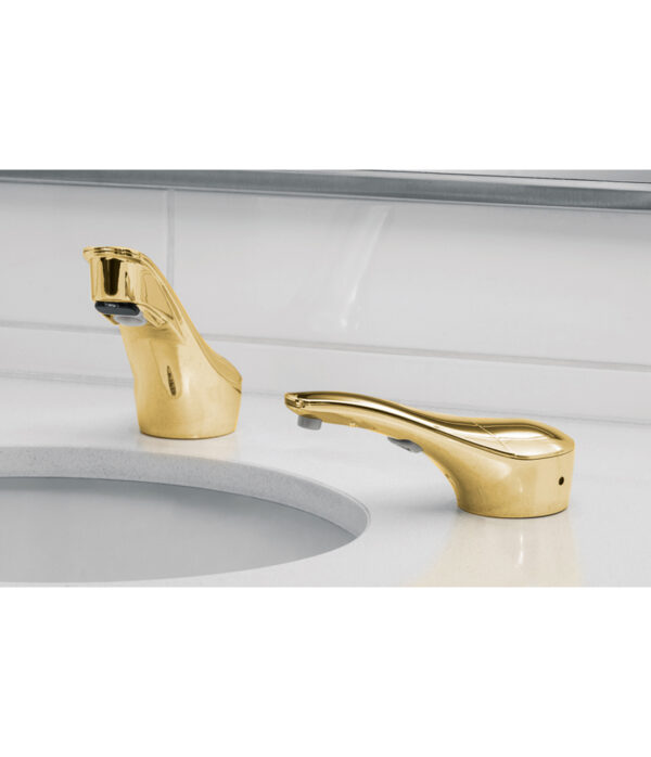 Bathroom sink with gold faucets on white countertop and backsplash.