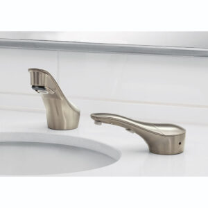 Modern brushed metal bathroom faucet, separate handle, white countertop, tiled backsplash.