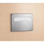Stainless steel paper towel dispenser on beige tiled wall.