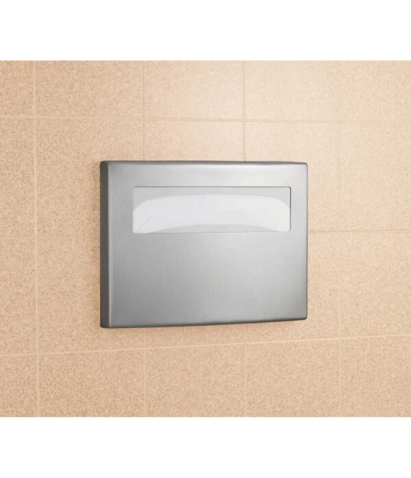 Stainless steel paper towel dispenser on beige tiled wall.