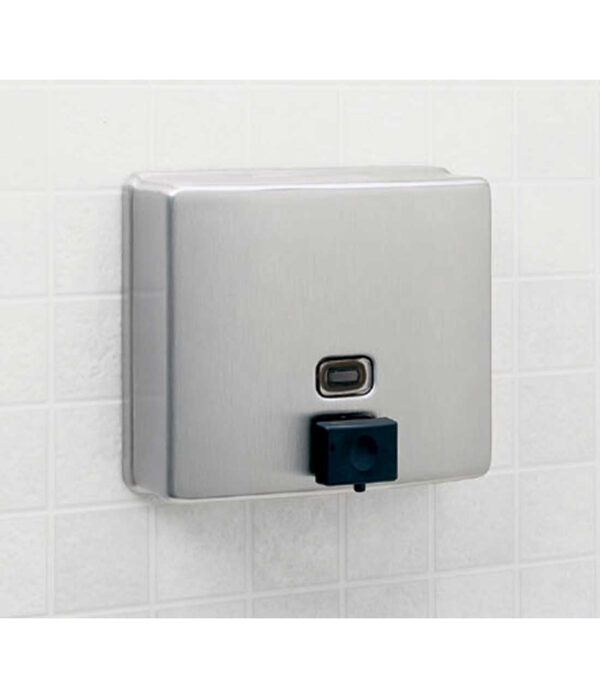 Stainless steel soap dispenser with sensor on tiled bathroom wall.