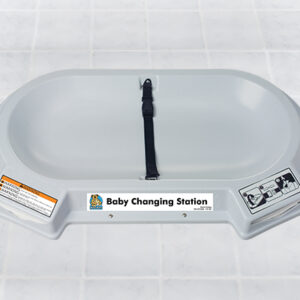 Wall-mounted baby changing station with safety strap and instructional use labels.