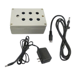 White electronic box with round openings, includes plug adapter and connector cable.