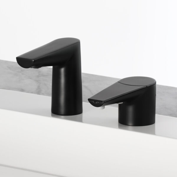Two modern black faucets on white surface with gray marble background.