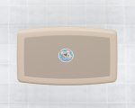 Wall-mounted baby changing station with koala logo on tiled wall.