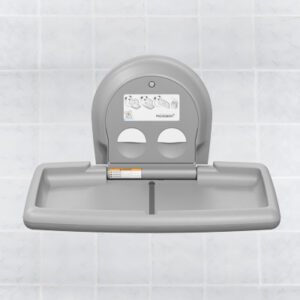 Wall-mounted gray baby changing station open against a tiled wall with instructions visible.
