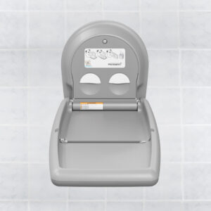 Wall-mounted fold-down baby changing station in light gray plastic with usage instructions.