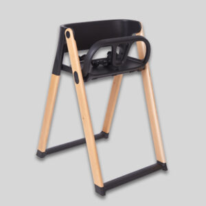 Modern high chair with black seat, light wood legs, safety harness, footrest, minimalist design.